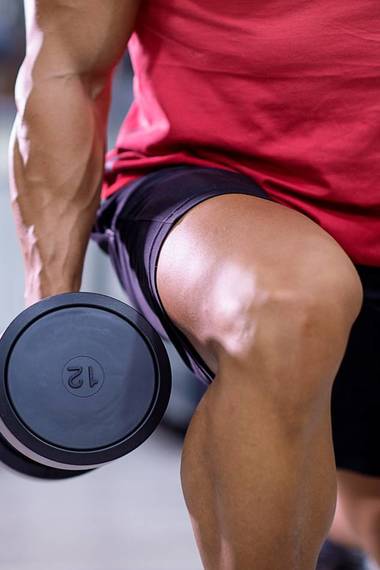 Close up of a male athlete weight training in the gym