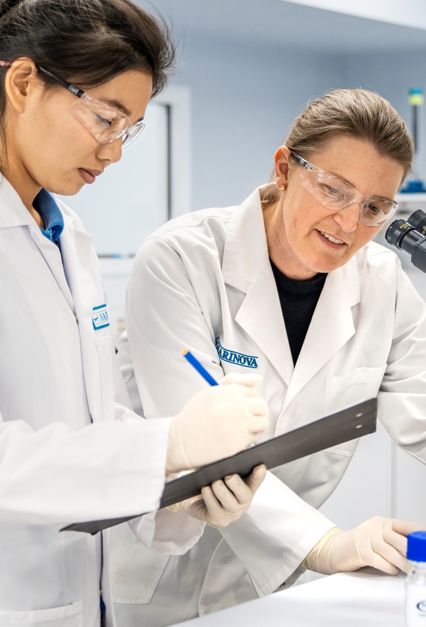 Tania Zulkifly and Amanda Mackinnon working in lab in labcoats