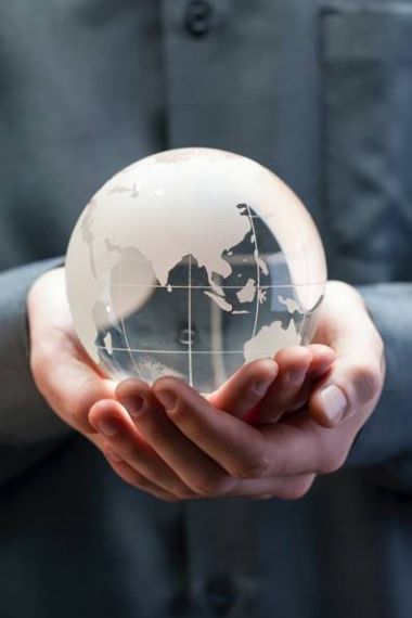 Person holding a world globe in the palm of their hands